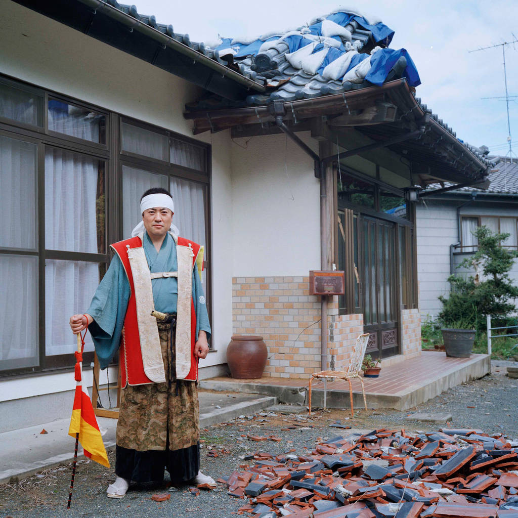 Kunihito, 40 in front of his parents' house  “I lived here since I was born until the disaster occurred. Roof tiles fell off and walls cracked due to the earthquake, but the house is habitable only if the level of radiation exposure was normal.” Currently he lives in a leased housing in the town near Odaka with his family and has been working since before the disaster at the Fukushima Daiichi nuclear plant.  September 2012